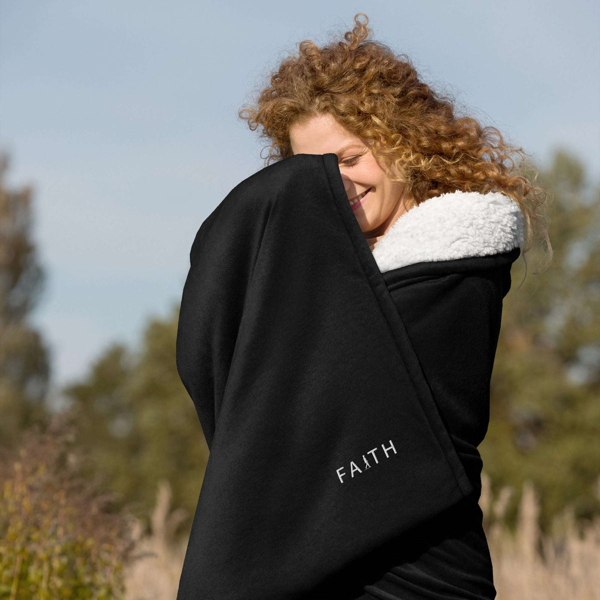 A soft, plush sherpa blanket from AIM ATTITUDE featuring a Faith design, perfect for cozying up on a sofa or bed.