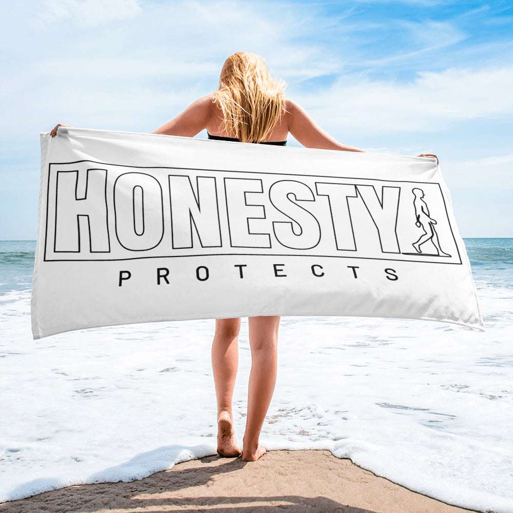 A white AIM ATTITUDE towel with the phrase "Honesty Protects" printed in bold black letters, laid flat on a neutral background.